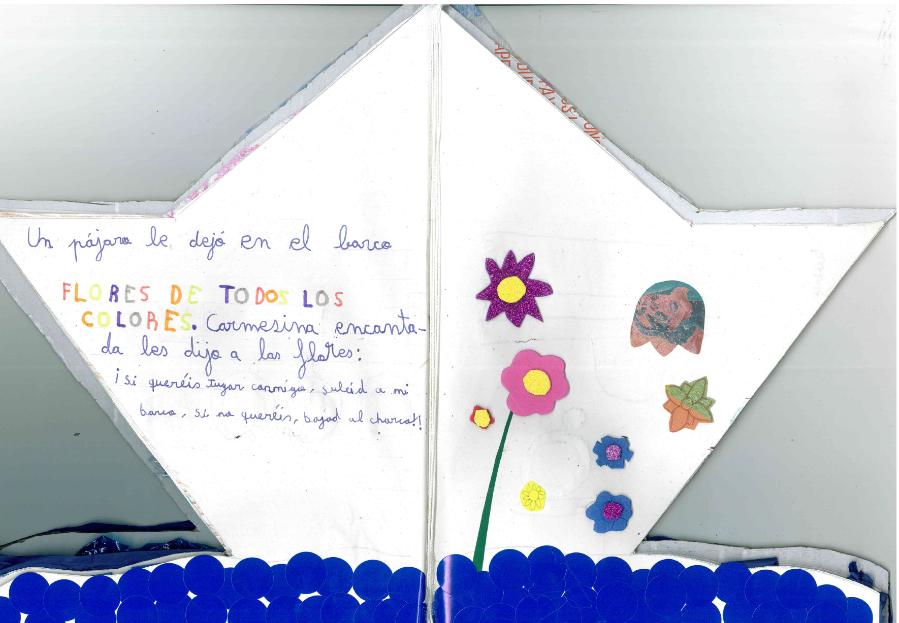 Texto manuscrito y en la derecha hay varios dibujos de flores de colores, parecen hechas con cartulinas o goma eva y pegadas en el folio. 