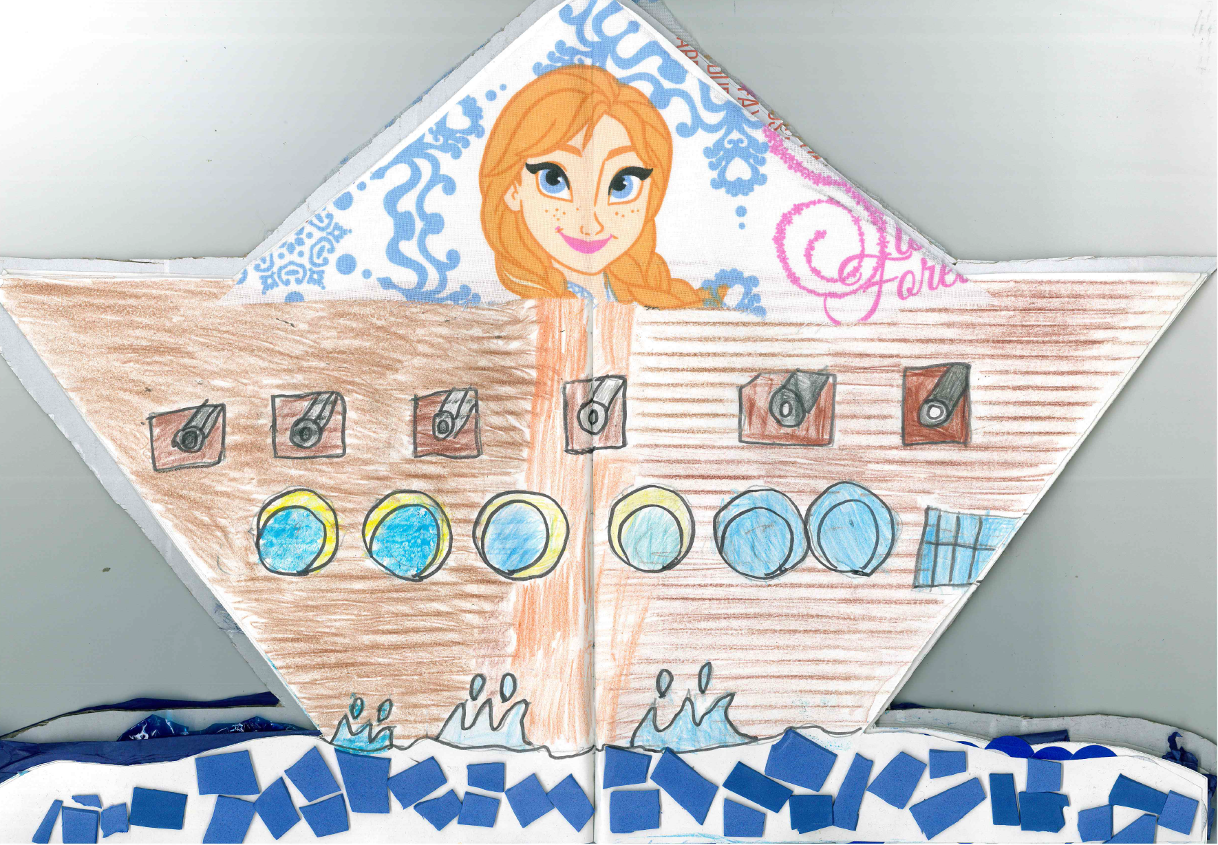 una dibujo de c mo est hecho el libro viajero, aparece el barco recortado y arriba est  el rostro de lo que parece ser un personaje infantil de cuentos, una ni a con trenzas y ojos azules.